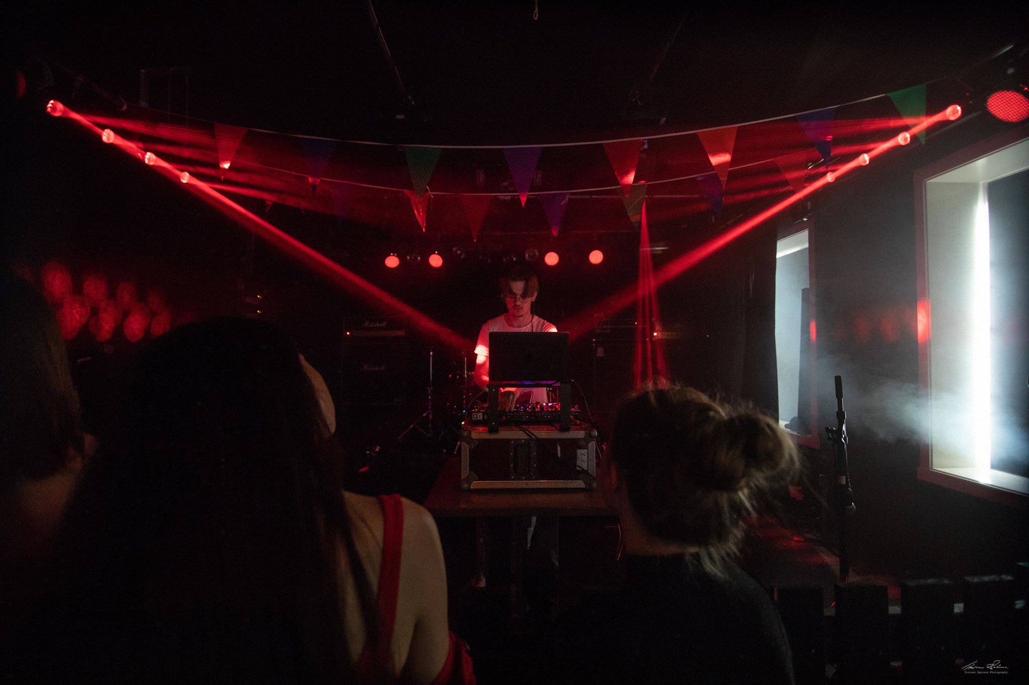 Ean performing in a room lit with red stage lights